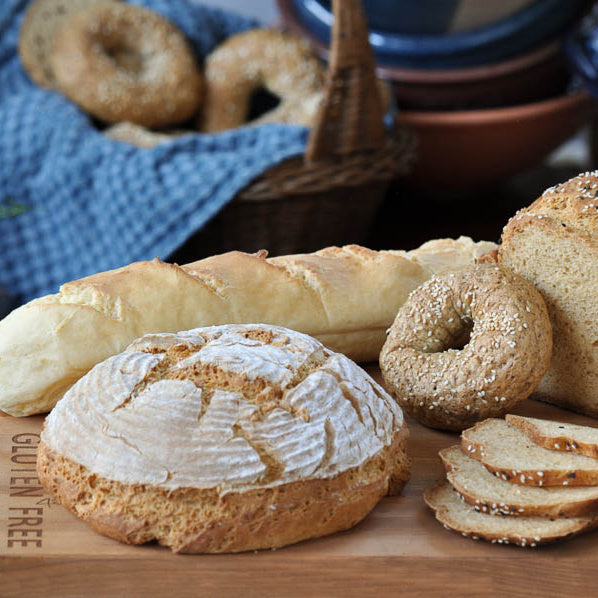 Gluten-free bread mix by gfJules with a bag of gluten-free baking ingredients and freshly baked bread slices on a wooden surface.