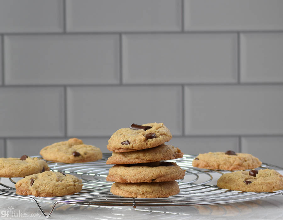 Stack of gfJules gluten-free chocolate chip cookies cooling on a rack, showcasing the delicious, freshly baked treats.