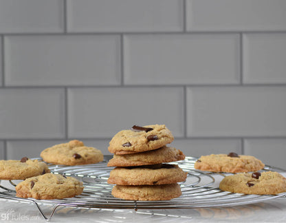 Stack of gfJules gluten-free chocolate chip cookies cooling on a rack, showcasing the delicious, freshly baked treats.