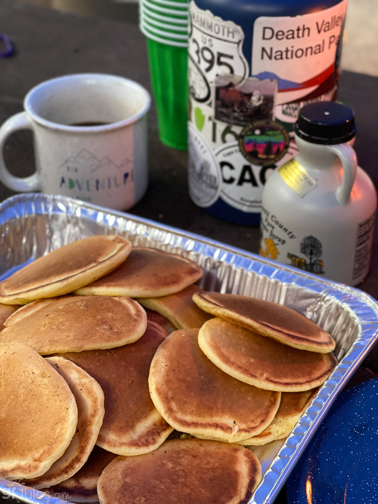 Gluten-free pancake and waffle mix by gfJules, showing a prepared stack of fluffy pancakes topped with syrup and fresh fruit.