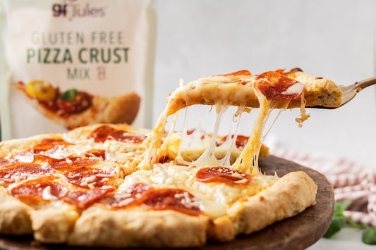 Gluten-free pizza crust mix by gfJules displayed on a wooden surface with prepared crust ready for toppings.