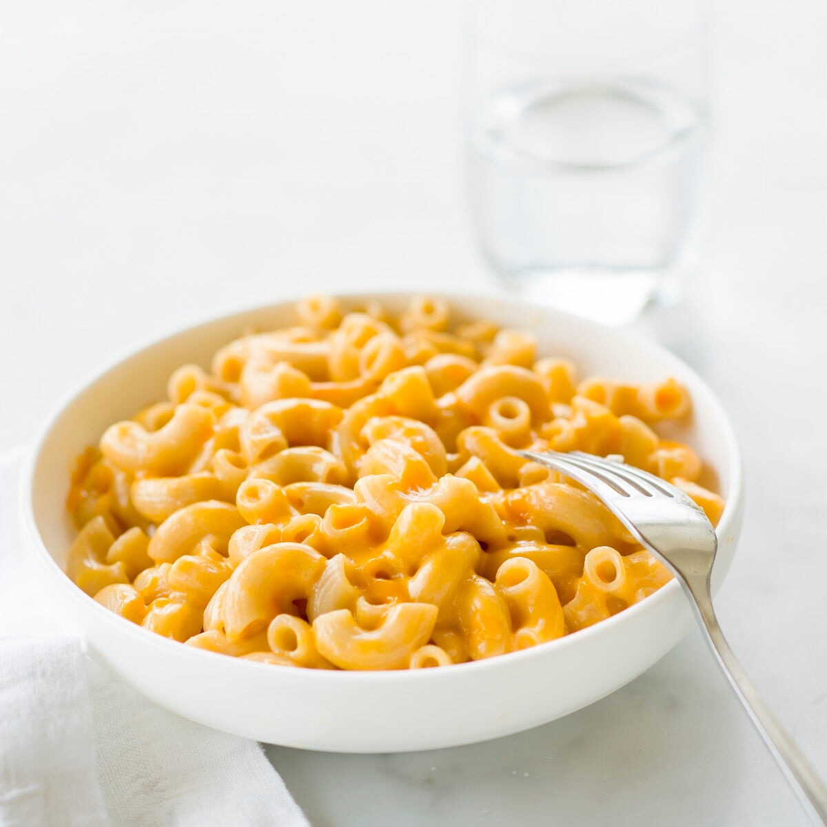 Jovial Gluten-Free Brown Rice Elbows pasta in a clear bowl, showing the short, curved brown rice pasta shape.