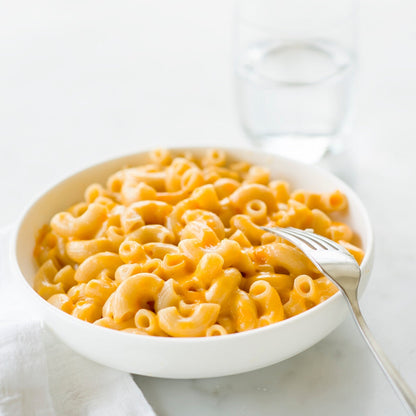 Jovial Gluten-Free Brown Rice Elbows pasta in a clear bowl, showing the short, curved brown rice pasta shape.