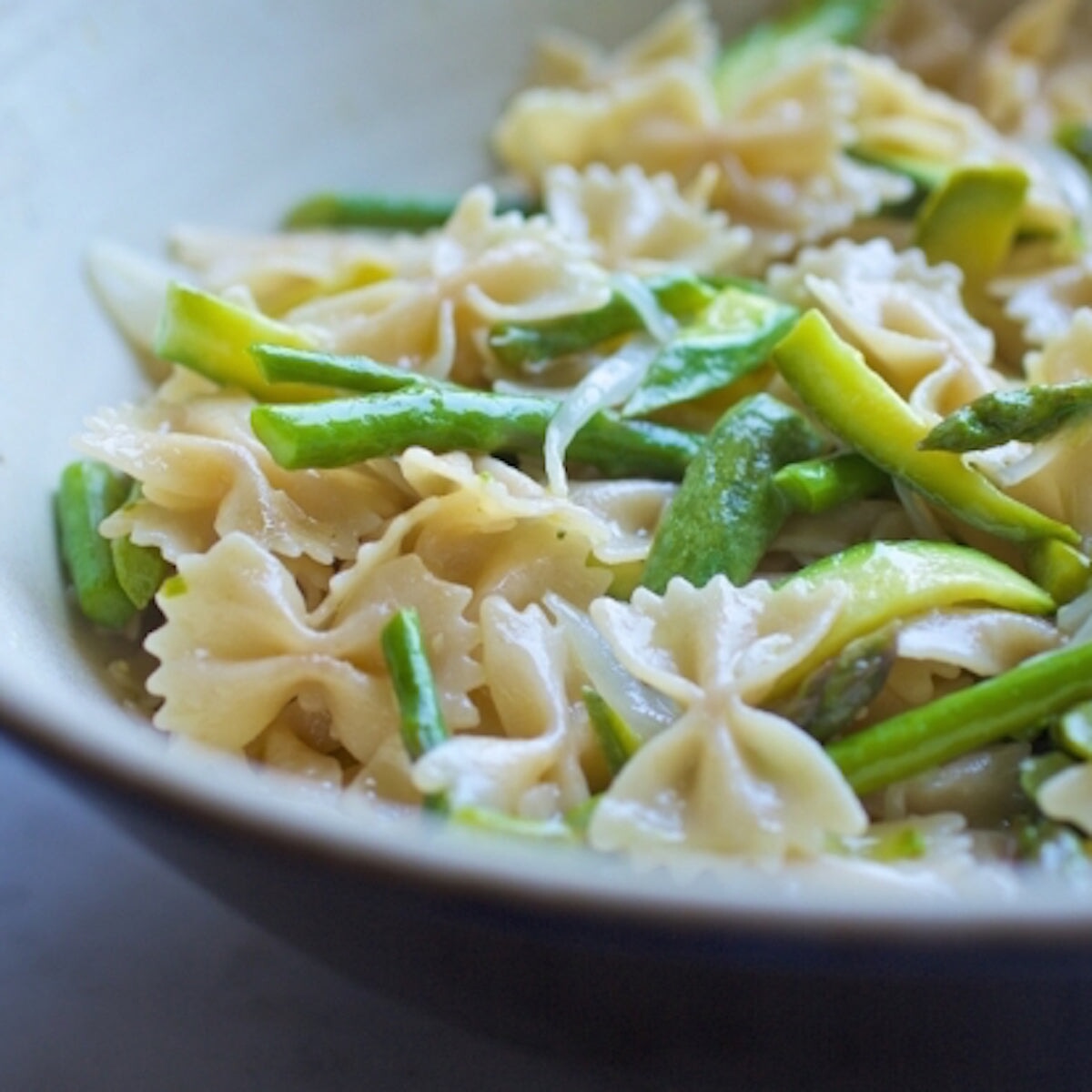 Jovial Gluten-Free Brown Rice Farfalle pasta in a clear bowl, showing the bowtie-shaped brown rice pasta on a white background.