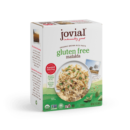 Jovial Gluten-Free Brown Rice Mafalda pasta, uncooked, showing short, thick pasta strands on a white background.