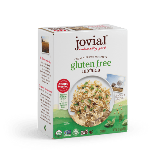 Jovial Gluten-Free Brown Rice Mafalda pasta in a clear bowl, showcasing the light brown, short, ridged pasta strands.