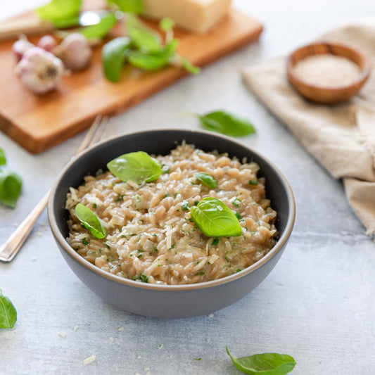 Jovial gluten-free brown rice orzo pasta in a bowl with herbs, ready for cooking, by Jovial Foods, Inc.