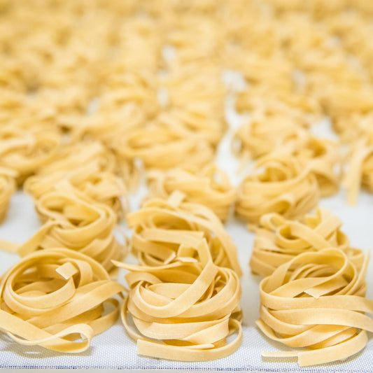 Jovial gluten-free brown rice pasta egg tagliatelle on a plate, showcasing the pasta's texture and golden color.