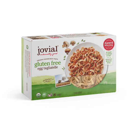 Jovial Gluten Free Brown Rice Pasta Egg Tagliatelle, uncooked, in a package showing the pasta strands and branding.