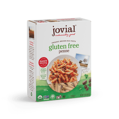 Jovial Gluten-Free Brown Rice Penne Rigate pasta in a bowl, showcasing the uncooked pasta's shape and texture.