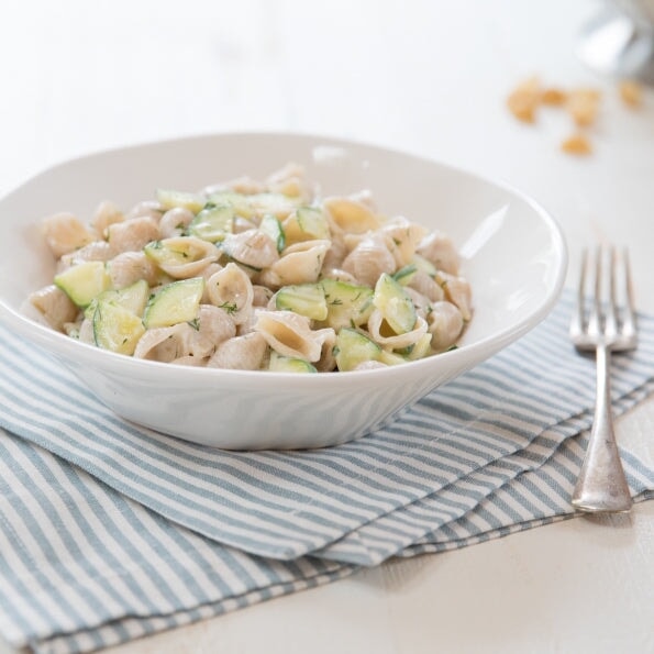 Gluten-free brown rice shells pasta by Jovial Foods, Inc, showing uncooked brown rice shell-shaped pasta on a white background.