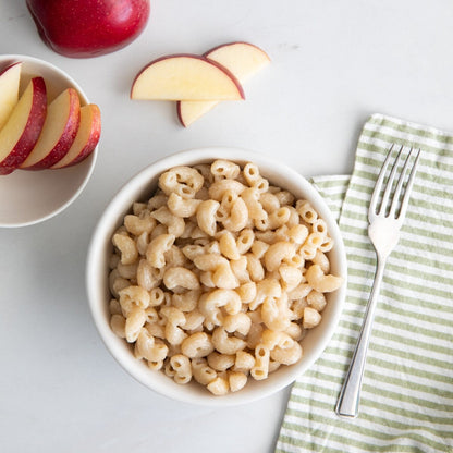 Jovial Gluten Free White Cheddar Mac and Cheese in a bowl, served with pasta and cheese sauce, on a wooden table.