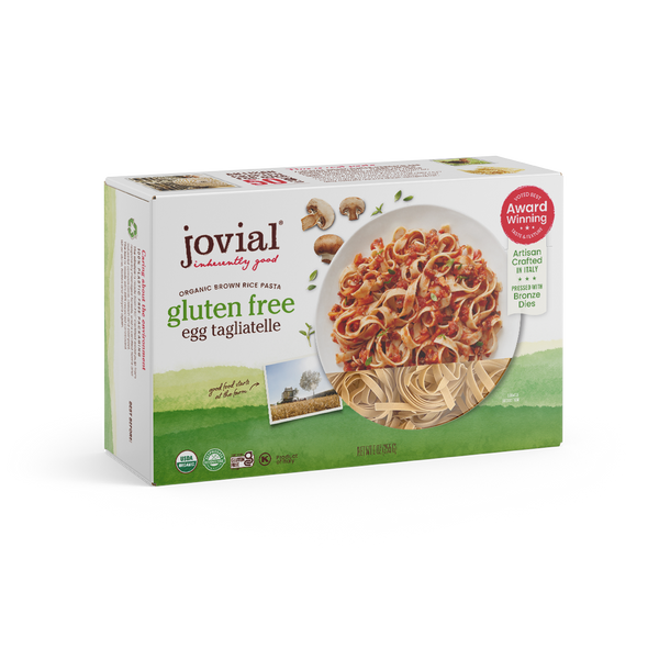 Jovial Gluten Free Brown Rice Pasta Egg Tagliatelle, uncooked, in a package showing the pasta strands and branding.