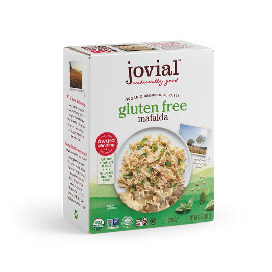 Jovial Gluten-Free Brown Rice Mafalda pasta in a clear bowl, showcasing the light brown, short, ridged pasta strands.