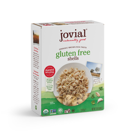 Jovial gluten free brown rice shells in a clear jar, showing the light brown, shell-shaped rice pasta on a white background.