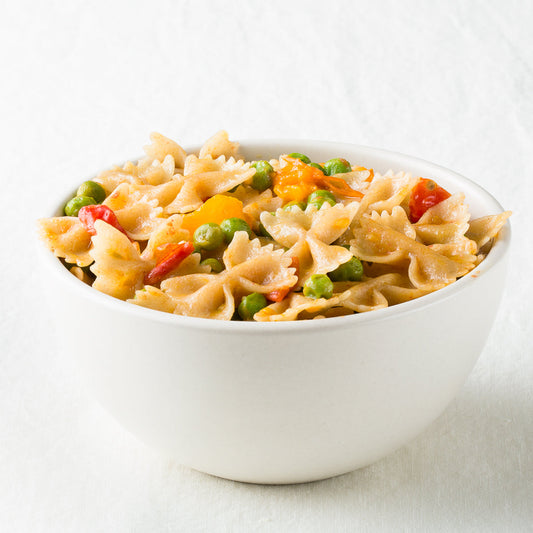 Jovial gluten-free brown rice farfalle pasta in a bowl, showcasing the pasta's shape and texture on a neutral background.