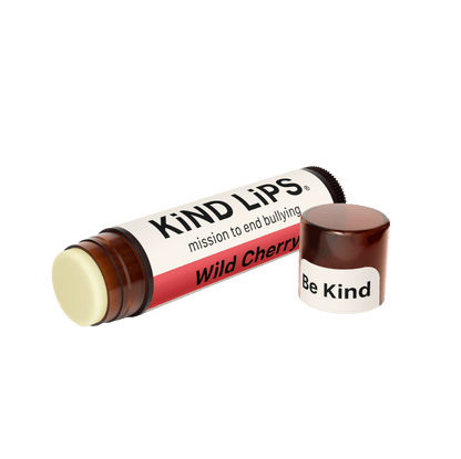 Kind Lips Wild Cherry Organic Lip Balm in a small tube, showcasing the natural product with cherry flavor and organic ingredients.