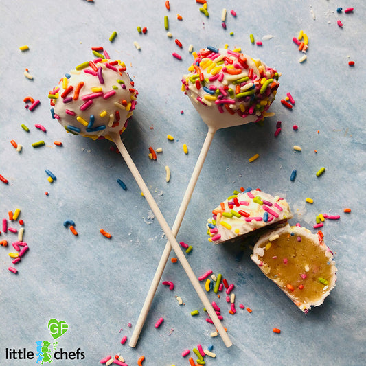 Colorful rainbow confetti cake pops by Little GF Chefs, featuring vibrant sprinkles on a white coating, perfect for celebrations.