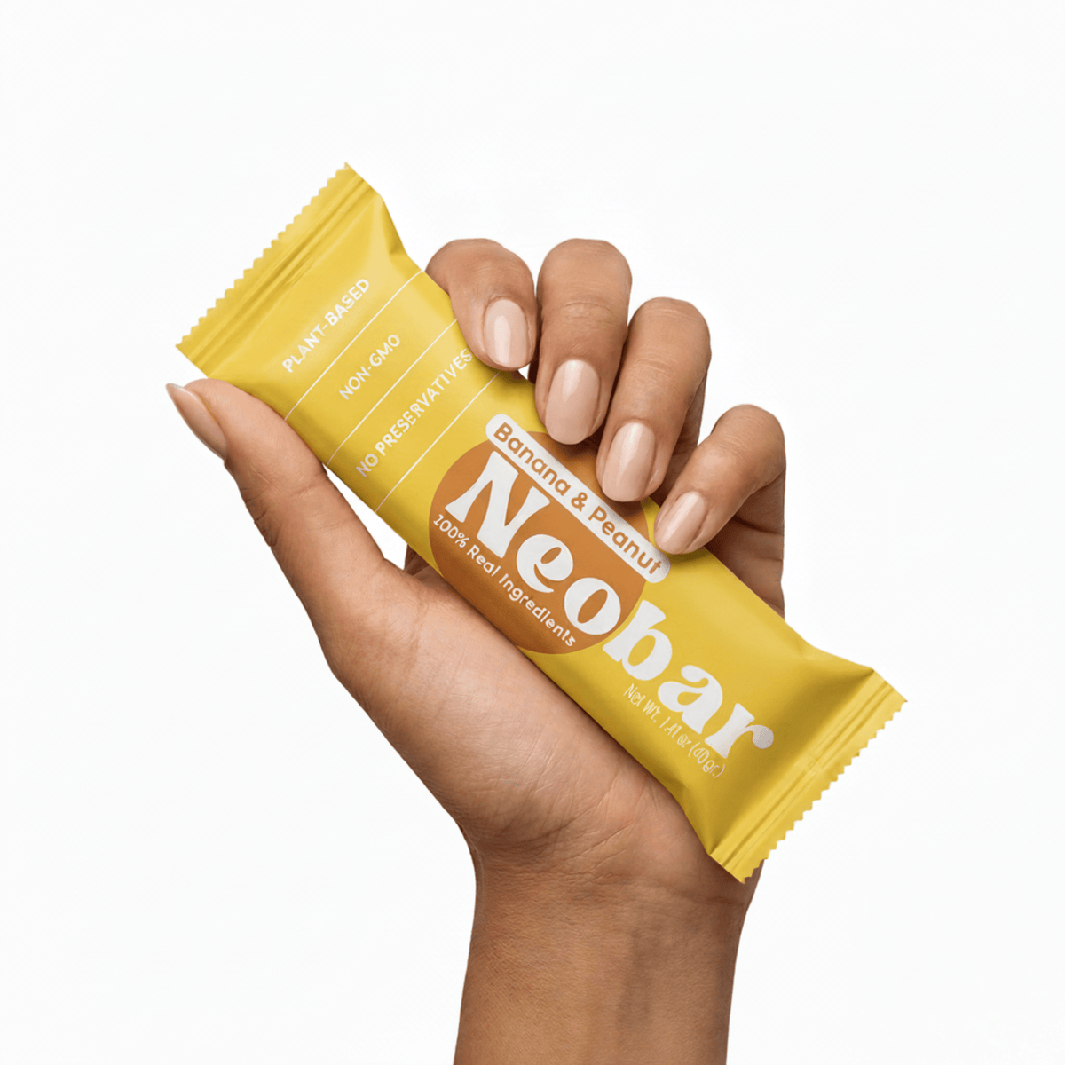 A hand holding a yellow Neobar banana and peanut protein bar against a solid white background.