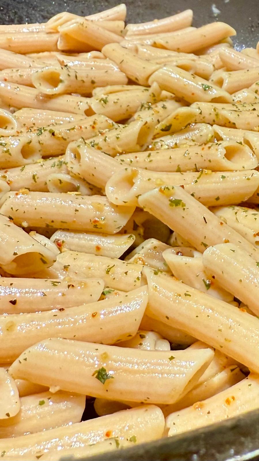 Six packs of Flower Chef Foods artisanal gluten-free, high-protein penne pasta in clear packaging with visible pasta inside.