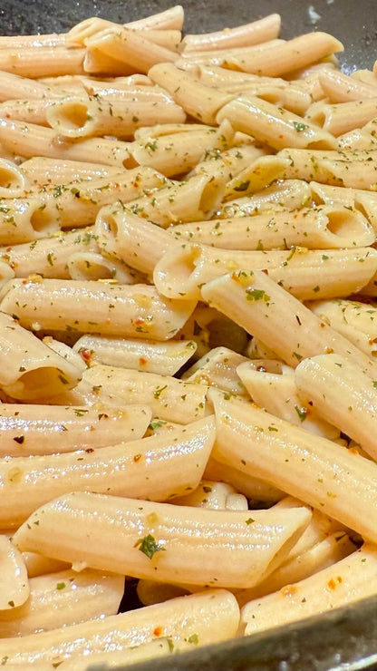 Six packs of Flower Chef Foods artisanal gluten-free, high-protein penne pasta in clear packaging with visible pasta inside.